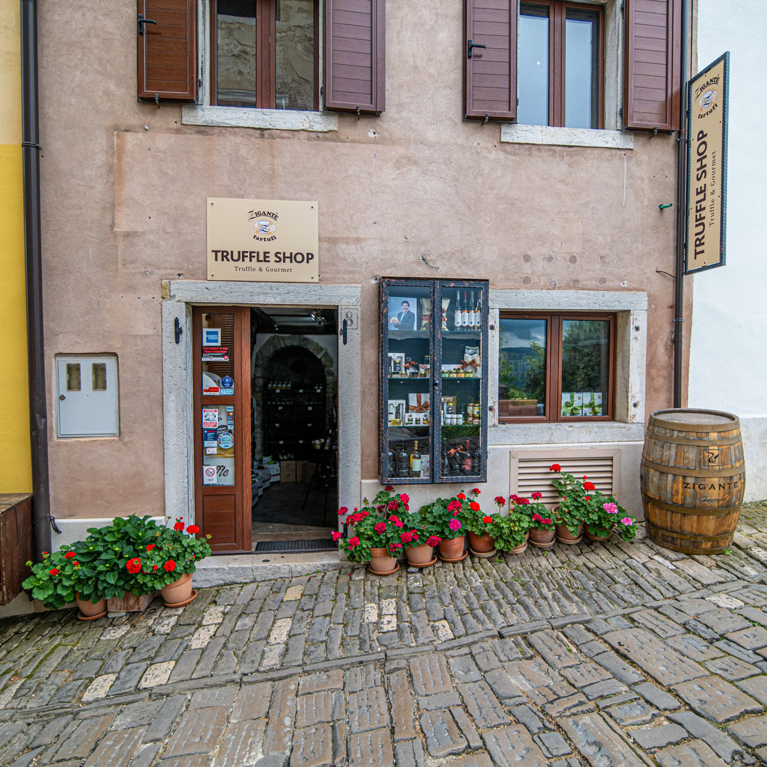 Zigante Tartufi truffle shop storefront in Motovun, Istria, Croatia, showing the entrance, logo sign, and product display windows